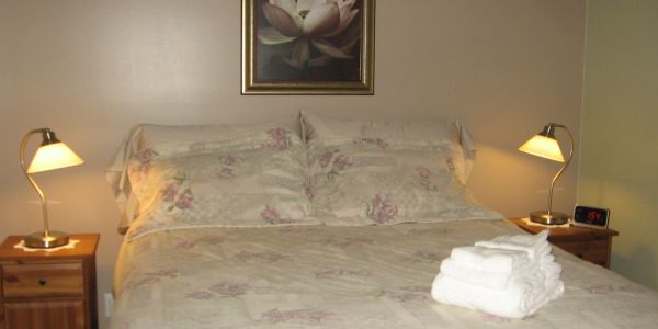 À l'ouest, chambre verte avec grand lit.